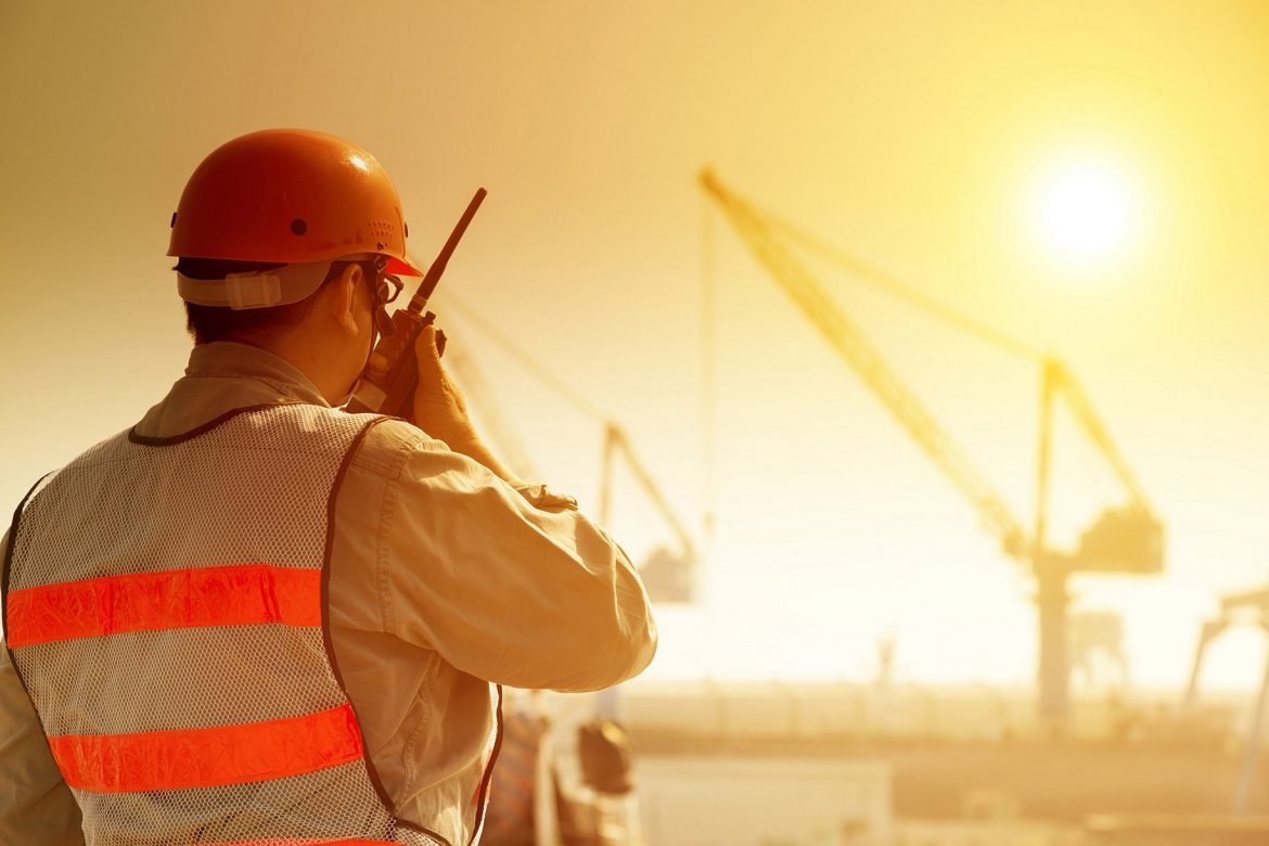Worker,With,Large,Crane,Site,And,Sunset,Background